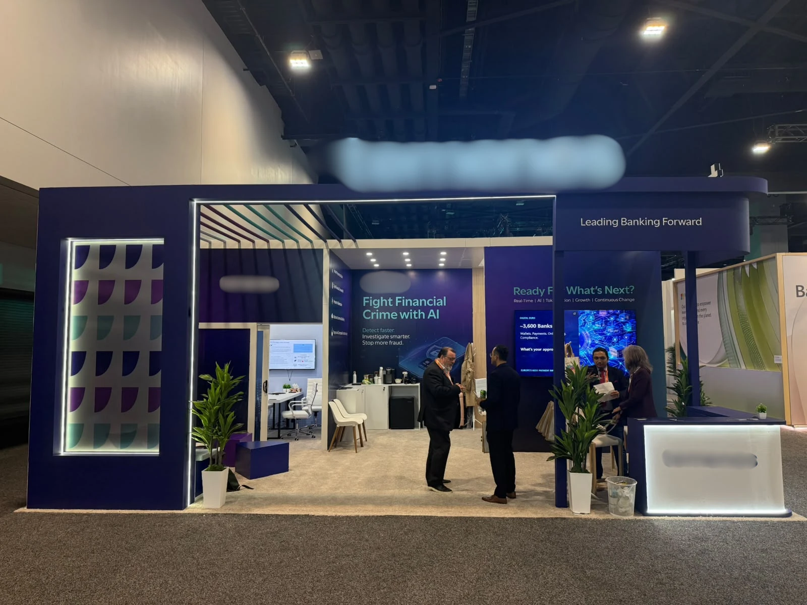 Navy blue custom exhibition stand with an LED-framed portal and lounge area at SIBOS 2026, Miami Beach Convention Center